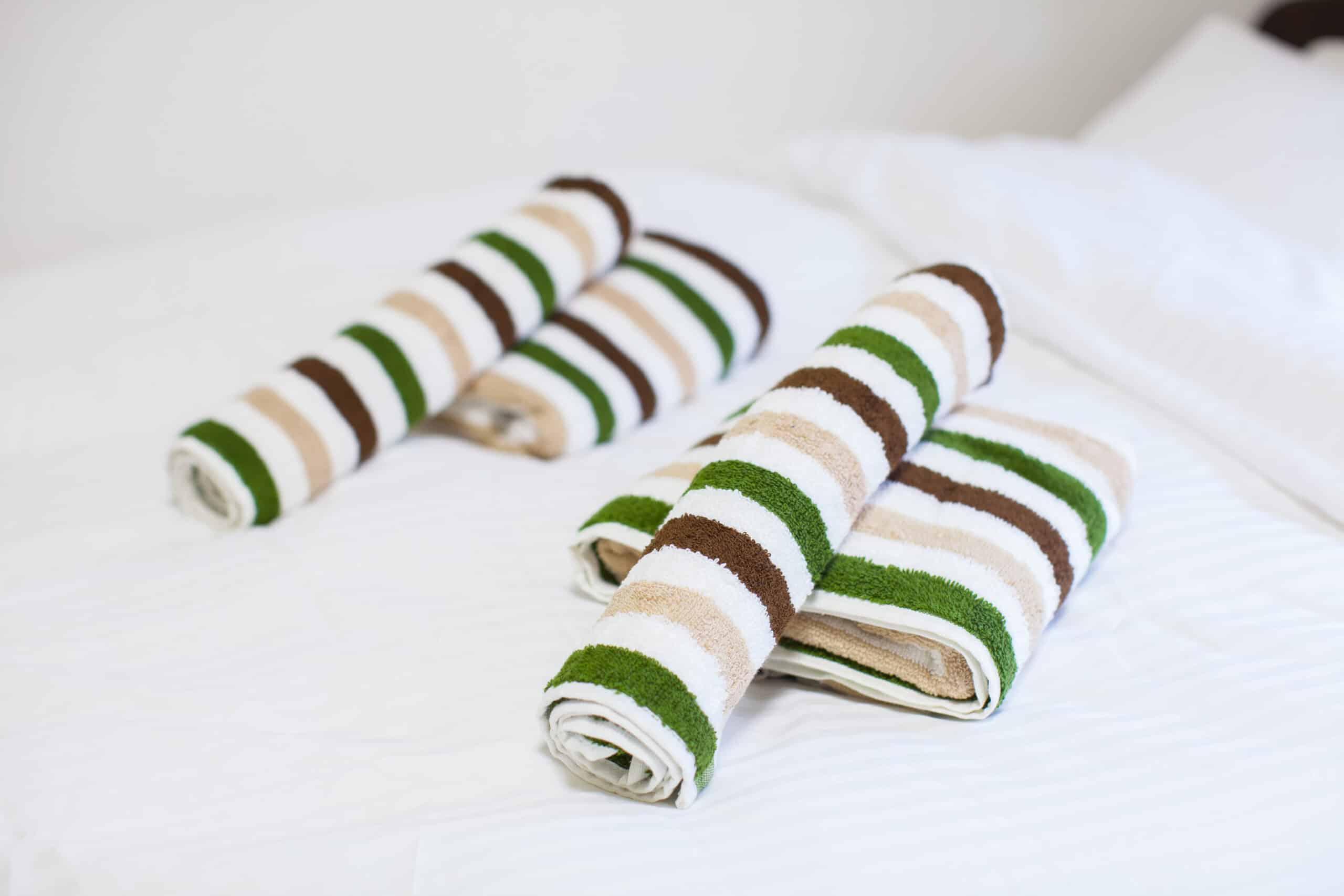 towels rolled up on a bed