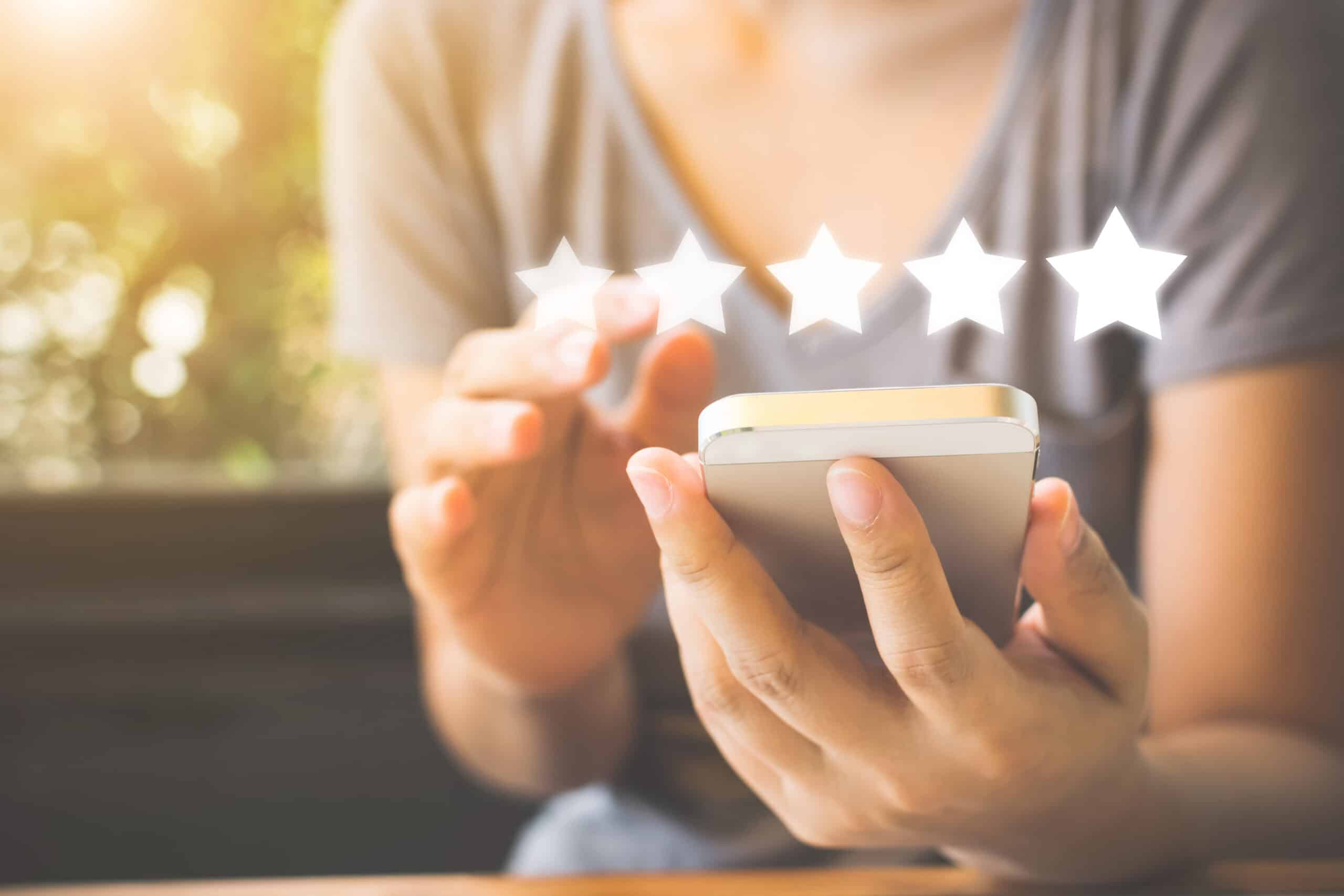 woman leaving 5 star review on smart phone